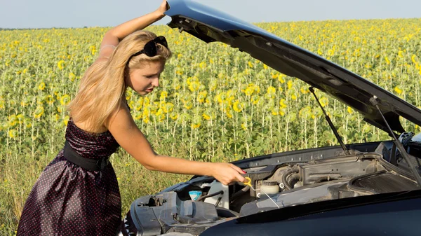 Mulher verificando o óleo do motor — Fotografia de Stock
