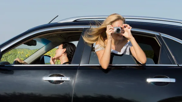 Kvinnan lutar sig ut ur bilen fotograferar — Stockfoto