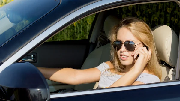 Молода жінка водій на мобільному телефоні — стокове фото