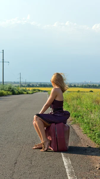 ファッショナブルな女性の道端でヒッチハイク — ストック写真