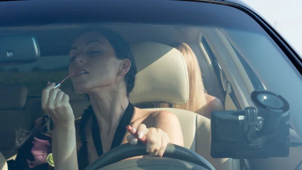 Mulher motorista aplicando batom — Fotografia de Stock