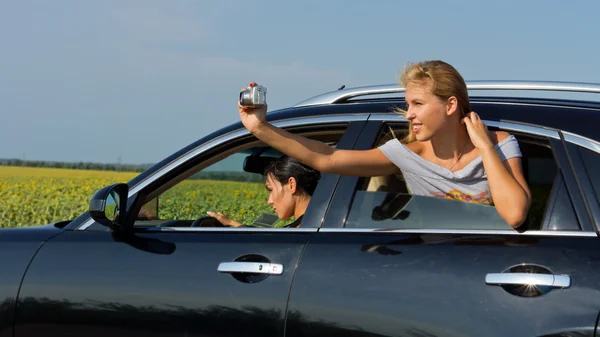 stock image Woman passenger leaning out of car taking photo