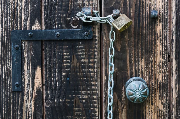 stock image Old wooden door with a chain