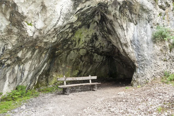 Сидение перед пещерой — стоковое фото