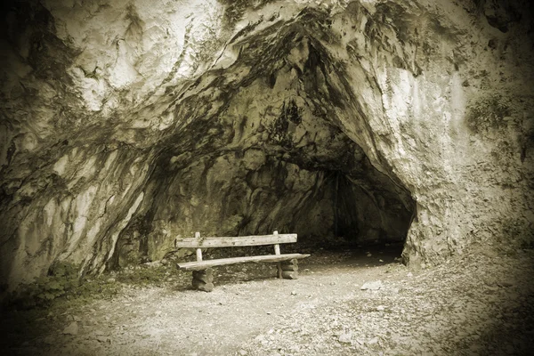 Сидение перед пещерой — стоковое фото