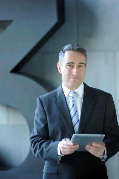 Geschäftsmann lächelt mit iPad — Stockfoto