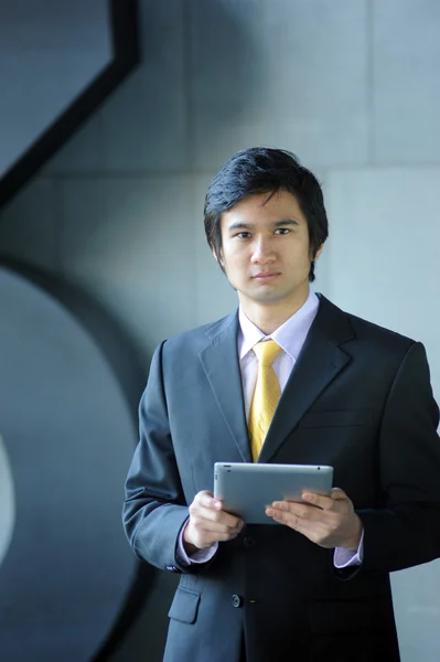 Azjatycki biznes człowiek ubrany w garnitur i krawat, tabletki. — Zdjęcie stockowe