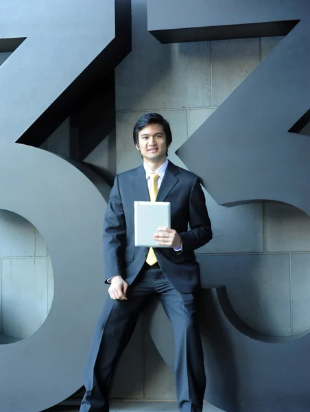 Asiático homem de negócios vestido de terno e gravata, sorrindo com tablet — Fotografia de Stock