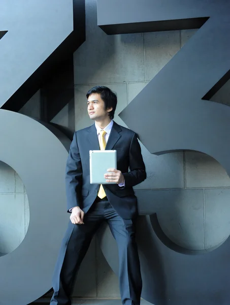 Asiatischer Geschäftsmann in Anzug und Krawatte, mit Tablet. — Stockfoto
