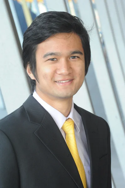 Ασιατικός επιχειρησιακός άνθρωπος ντυμένος με κοστούμι και γραβάτα, χαμογελώντας. Εικόνα Αρχείου