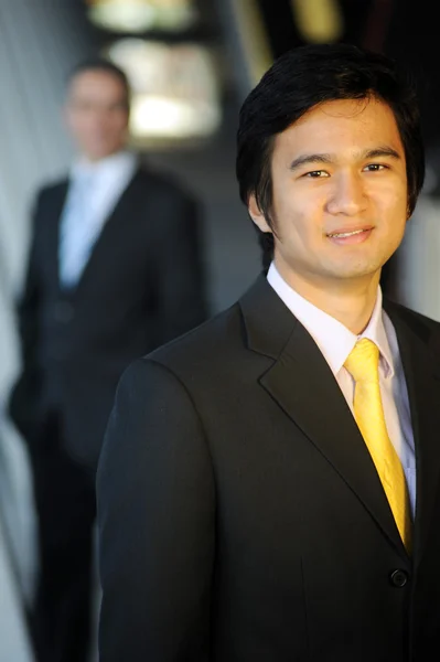 Ασιατικός επιχειρησιακός άνθρωπος ντυμένος με κοστούμι και γραβάτα, χαμογελώντας. Royalty Free Εικόνες Αρχείου