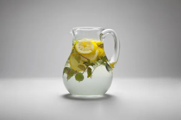Una jarra con la bebida fresca con el limón y la menta Fotos de stock