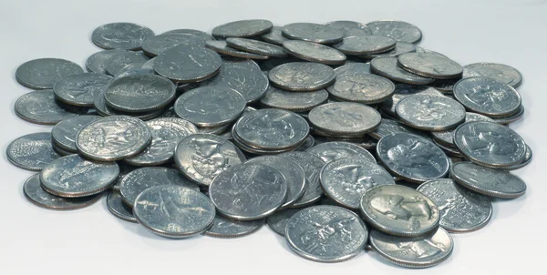 Hromada mincí čtvrtí na šedém pozadí — Stock fotografie