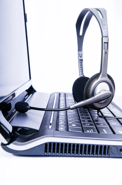 Laptop computer with headset on keyboard — Stock Photo, Image