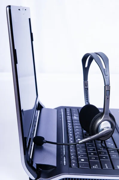 Laptop computer with headset on keyboard — Stock Photo, Image