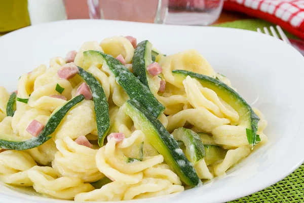 Orecchiette pasta met courgette, ham en kaas — Stockfoto