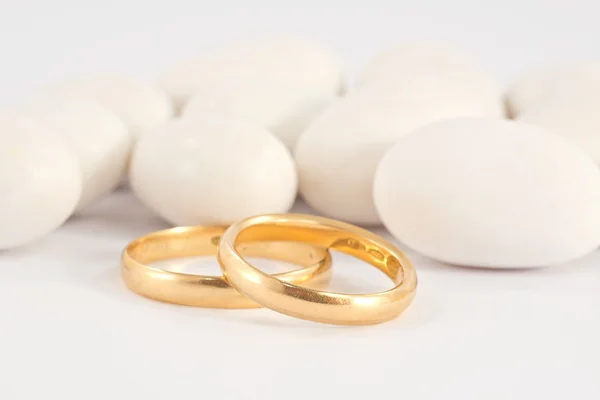 Wedding rings and white confetti — Stock Photo, Image