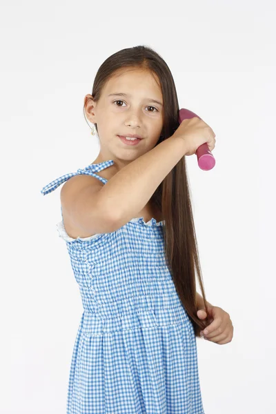 Menina bonita penteando seu cabelo longo — Fotografia de Stock