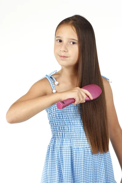 Menina bonita penteando seu cabelo longo — Fotografia de Stock