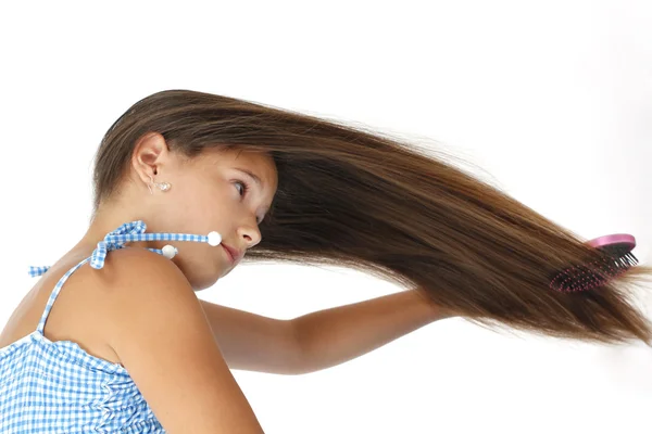 Menina bonita penteando seu cabelo longo — Fotografia de Stock