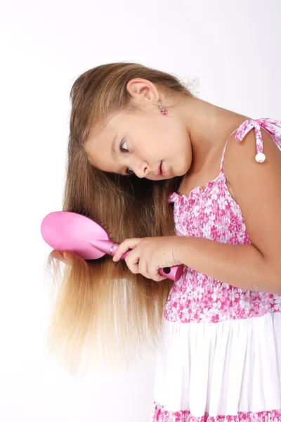 Beautiful little girl combing her long hair — Stock Photo, Image