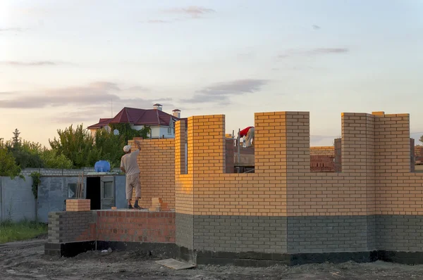 Byggandet av ett tegelhus. Stockbild