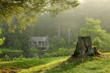 Old watermill in forest at dawn clipart