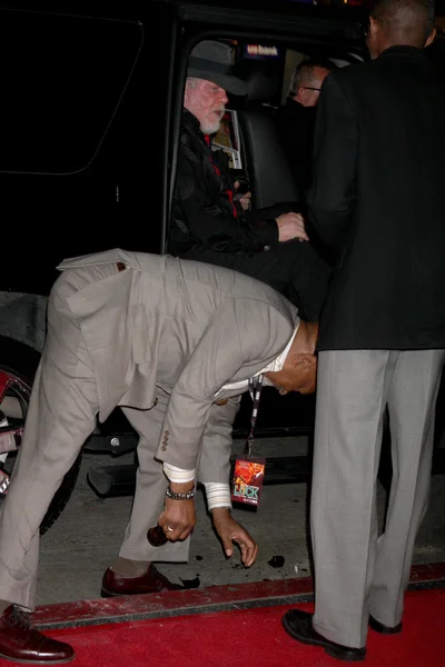 Nick Nolte, con Oscar Williams recogiendo una botella de cerveza que se cayó del coche cuando se abrió la puerta —  Fotos de Stock