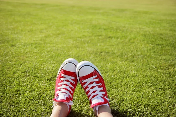Nohy v teniskách v zelené trávě — Stock fotografie