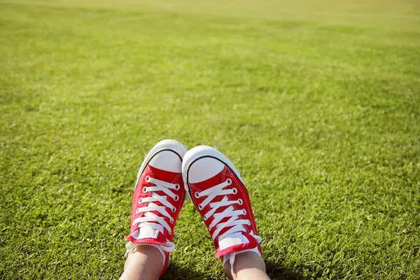 Πόδια σε sneakers σε πράσινο γρασίδι — Φωτογραφία Αρχείου