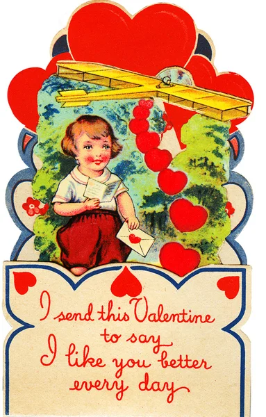 A boy with a valentine and a airplane behind him. — Stock Photo, Image