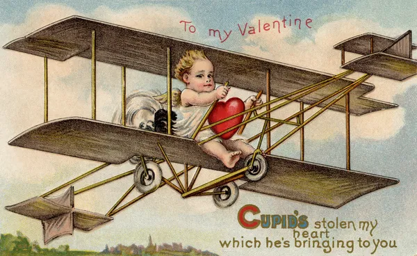 Una carta di San Valentino vintage con cupido che vola un aereo con un cuore rubato Fotografia Stock