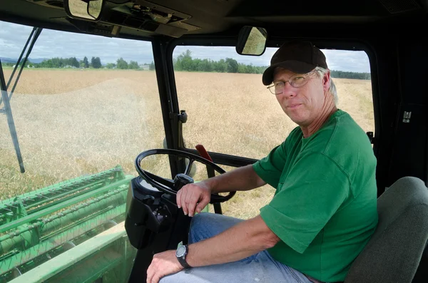 Farmář v kabině traktoru — Stock fotografie