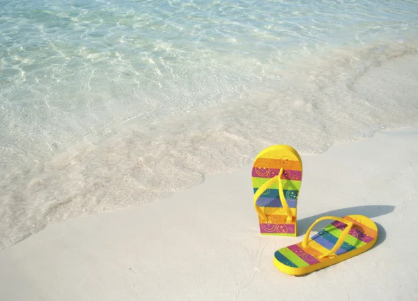 Um par de flip flops na areia da praia — Fotografia de Stock
