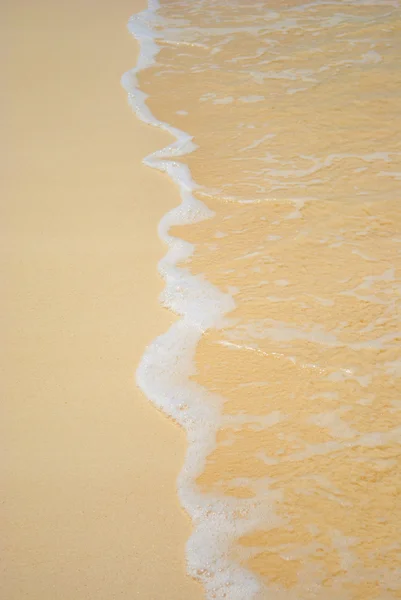 Jemný pěnivý surfovat na pláži — Stock fotografie