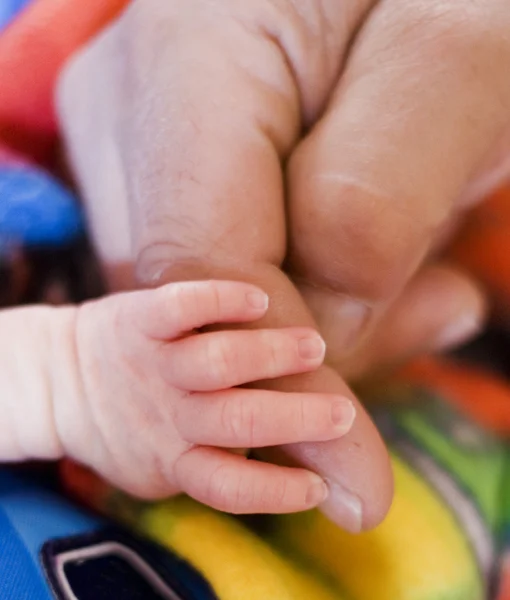 Mano de un bebé con la ayuda de un adulto — Foto de Stock