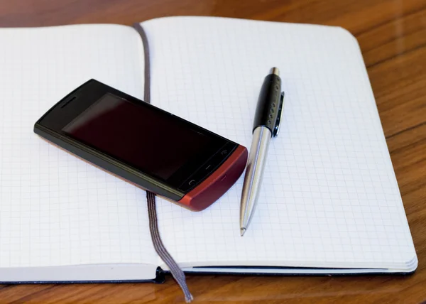 Книга, телефон і ручка — стокове фото
