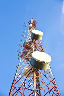 Telecommunication tower with antennas a blue sky. clipart