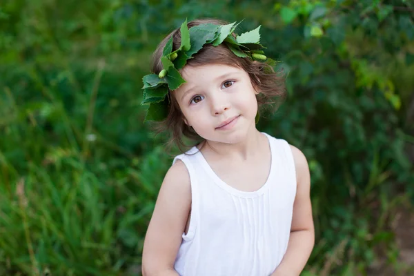 Porträt von niedlichen Mädchen mit einem Kranz im Freien — Stockfoto