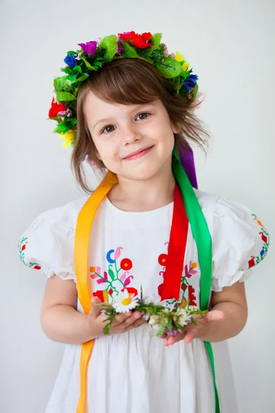Mooi meisje in etnische jurk met bloem krans — Stockfoto