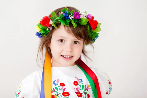 Mooi meisje in etnische jurk met bloem krans — Stockfoto