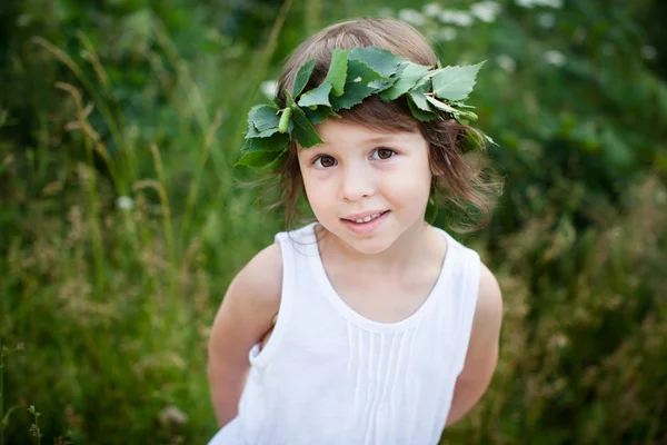 Retrato de menina bonito com uma grinalda ao ar livre — Fotografia de Stock
