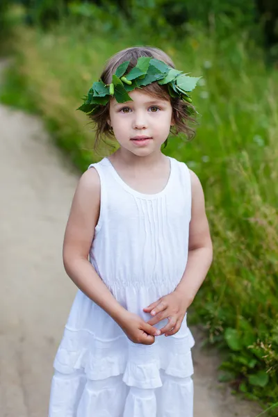 Porträt von niedlichen Mädchen mit einem Kranz im Freien — Stockfoto