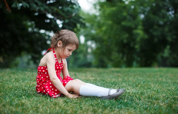 Roztomilé batole dívka sedící na trávě v parku — Stock fotografie