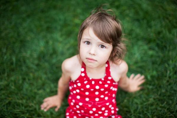 Klein meisje liggend op groen gras — Stockfoto