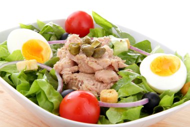 Mixed salad with tuna fish, eggs, onion and tomatoes clipart