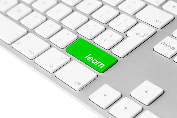 Клавиатура компьютера с зеленой кнопкой обучения — стоковое фото