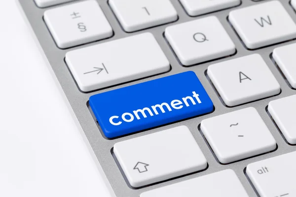 Tastatur mit einer blauen Taste mit dem Wort "Kommentar" Stockbild