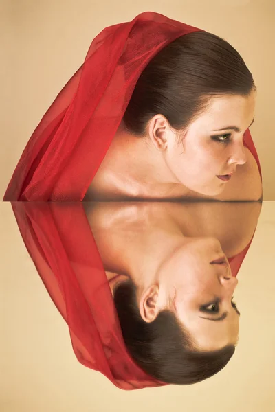 Een meisje met een rode deken in de spiegel — Stockfoto