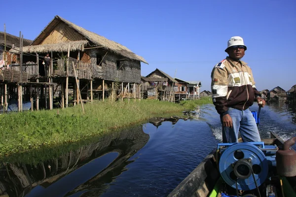 Burmesischer schiffer fährt durch schwimmendes dorf, inle lake, shan state, myanmar, südostasien — Stockfoto